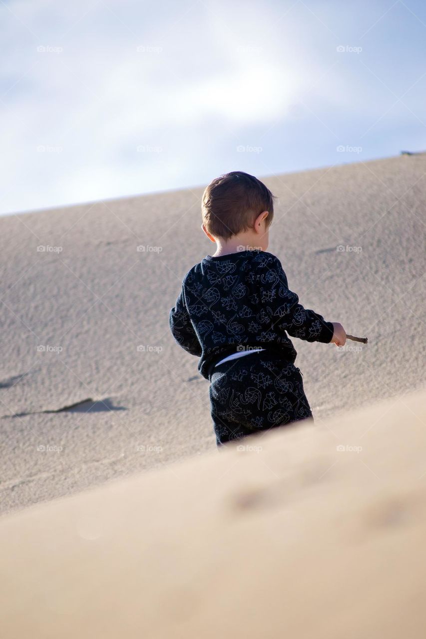 Little boy playing on the dunes