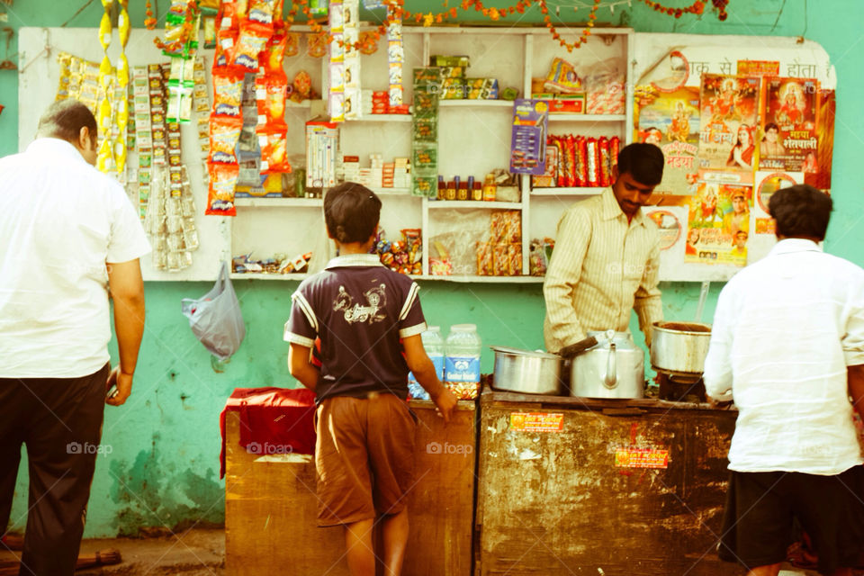 A little boy waiting to buy something at a store in India