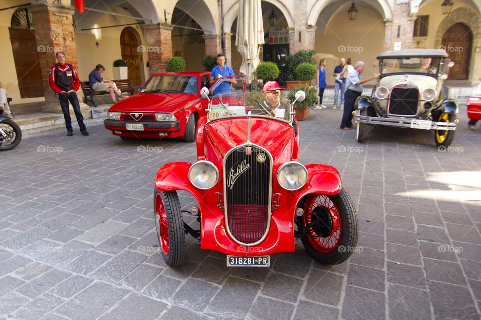 Senior man sitting in the red car