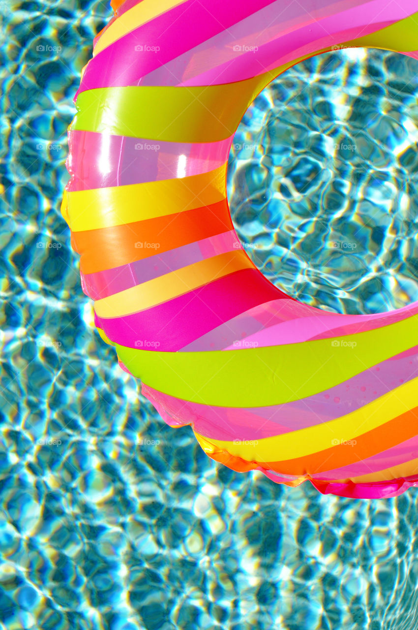 Colorful pool float in a refreshing blue swimming pool. 