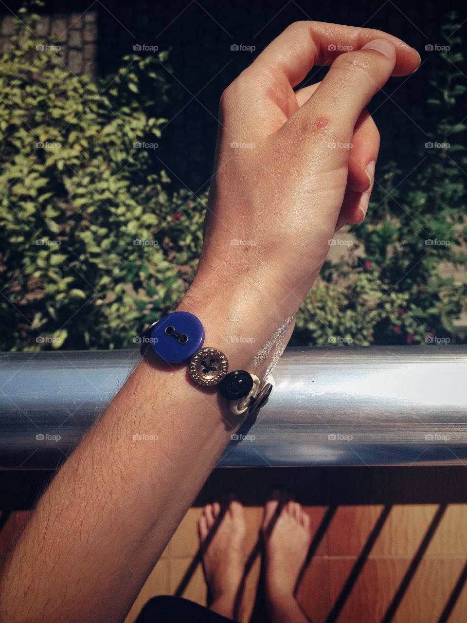 Hanging on the balcony, wearing a button bracelet made by myself. 