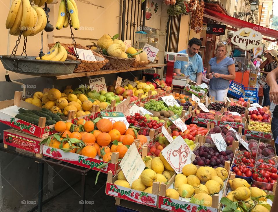 People buying fruit at market in Italy 