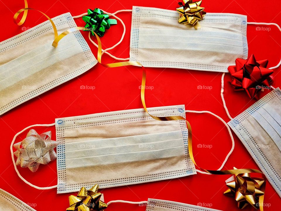 surgical masks against covid-19 on red background and festive decorations