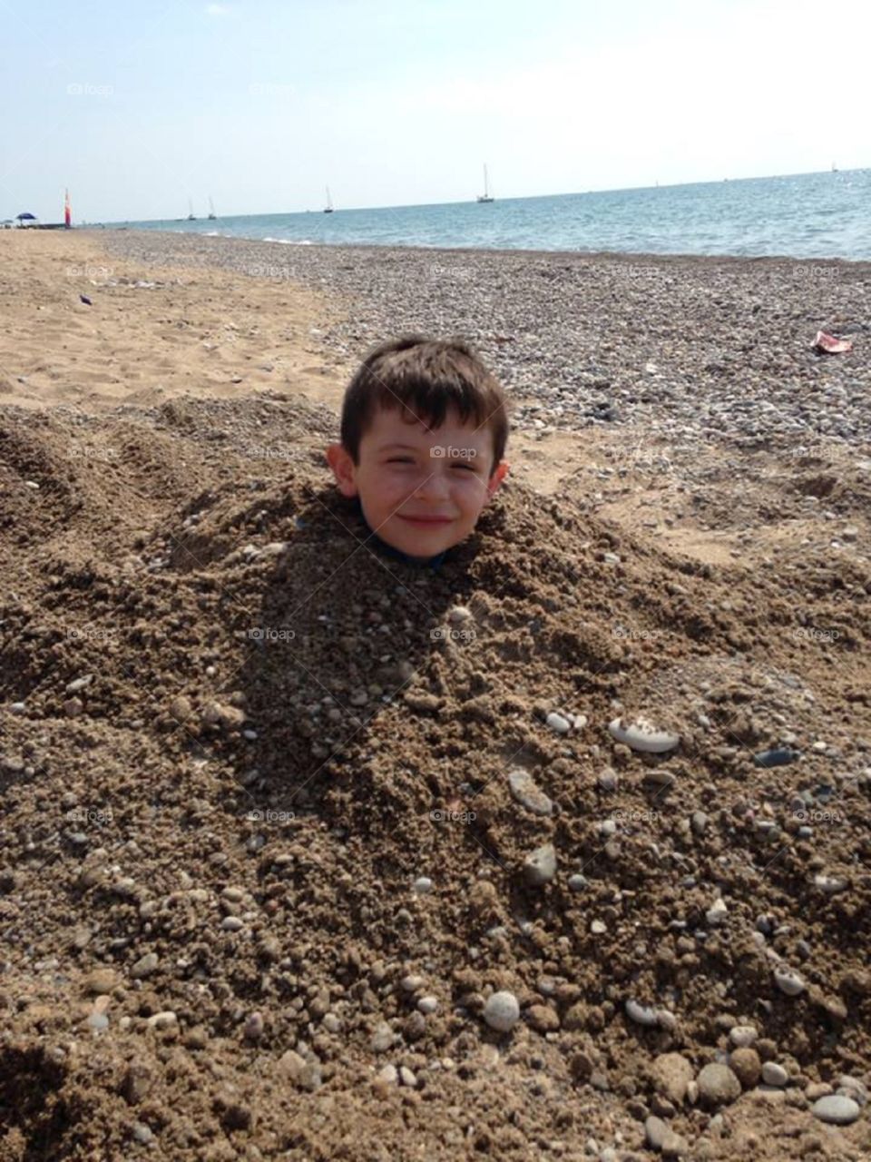 Boy buried in the sand . My favorite picture at the beach is my nephew buried in the sand!