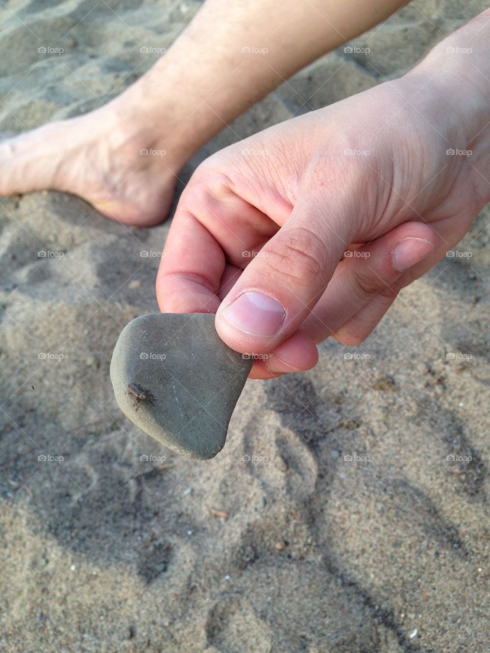 Beachin'. A hand holding a rock on the beach.