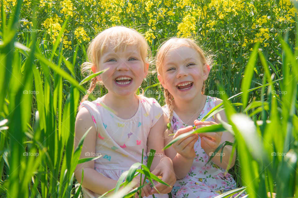 Portrait of two smiling sisters in field