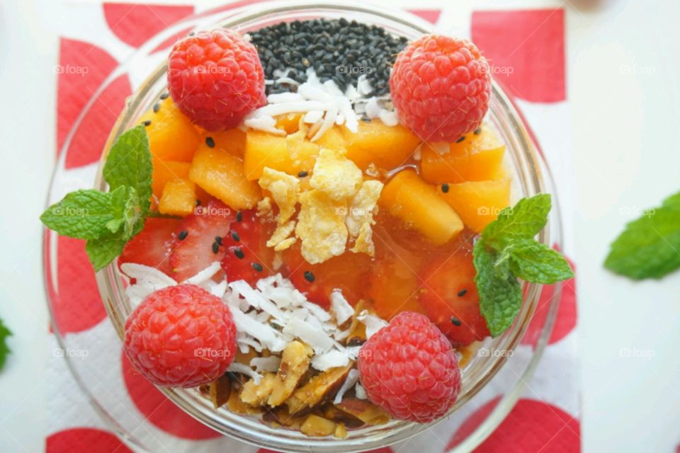 Smoothie fresh fruits bowl - peach, raspberry,  almonds,  strawberries,  coconut,  honey,  seeds and mints