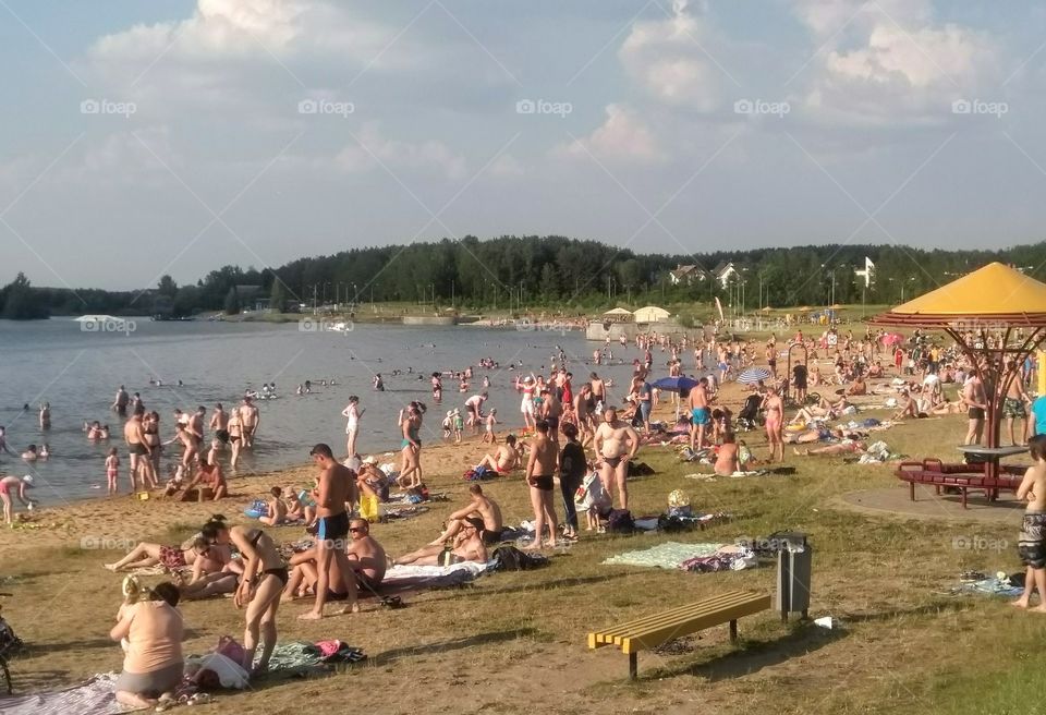 people resting on a lake shore summer heat