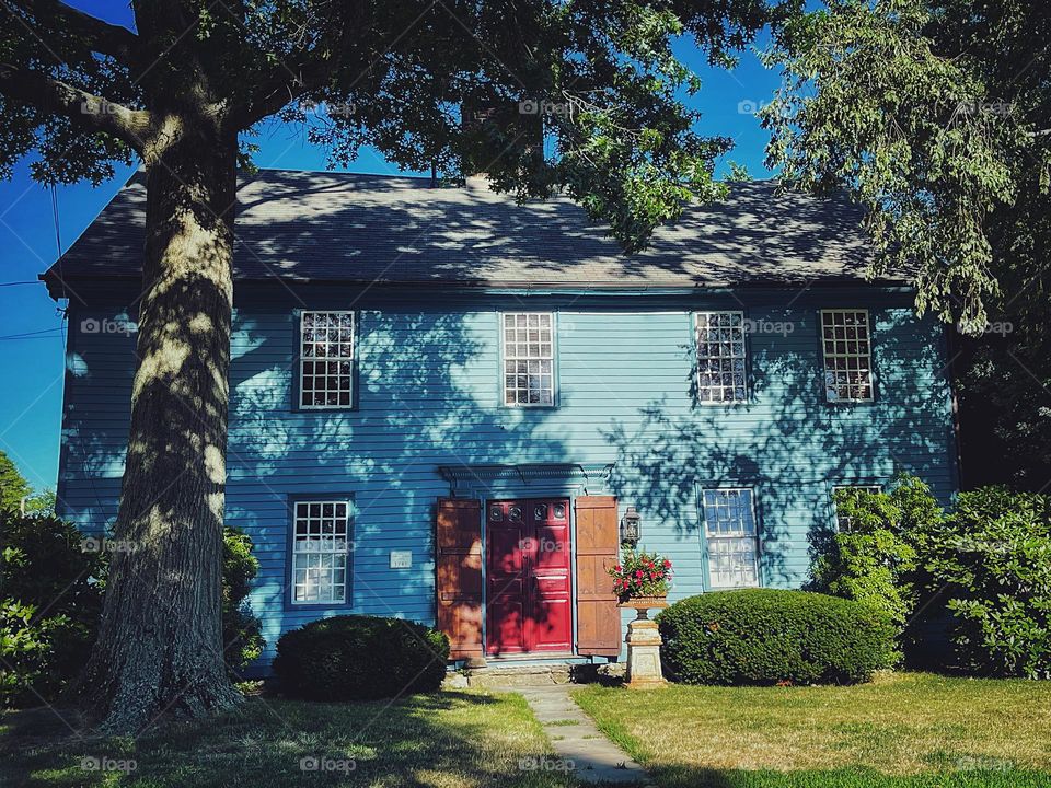 Blue historic house with a hidden red front door 