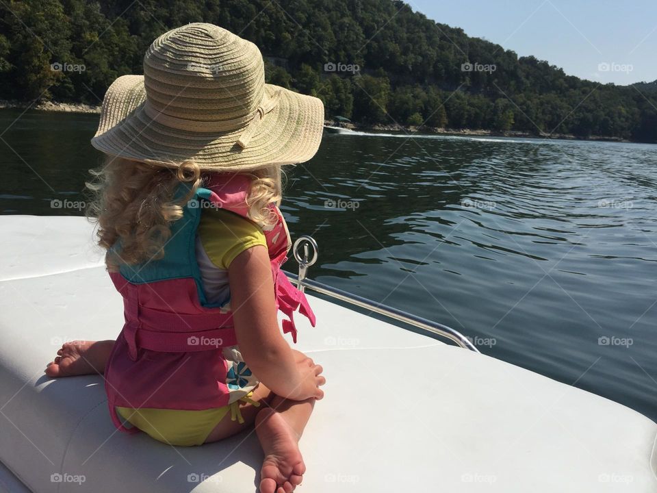 Little girl loving the summer out on a boat 