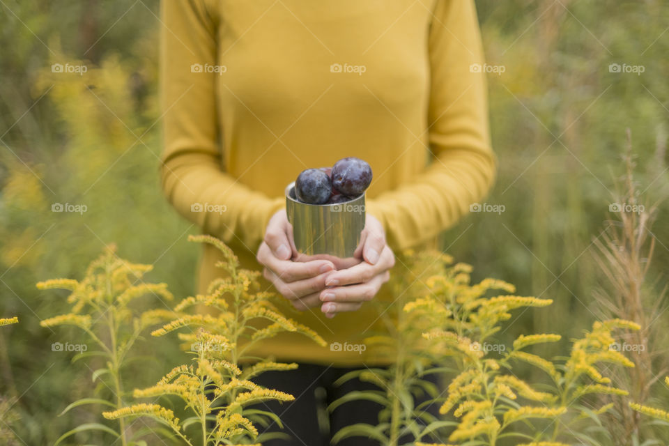 Girl holding a mug with plums