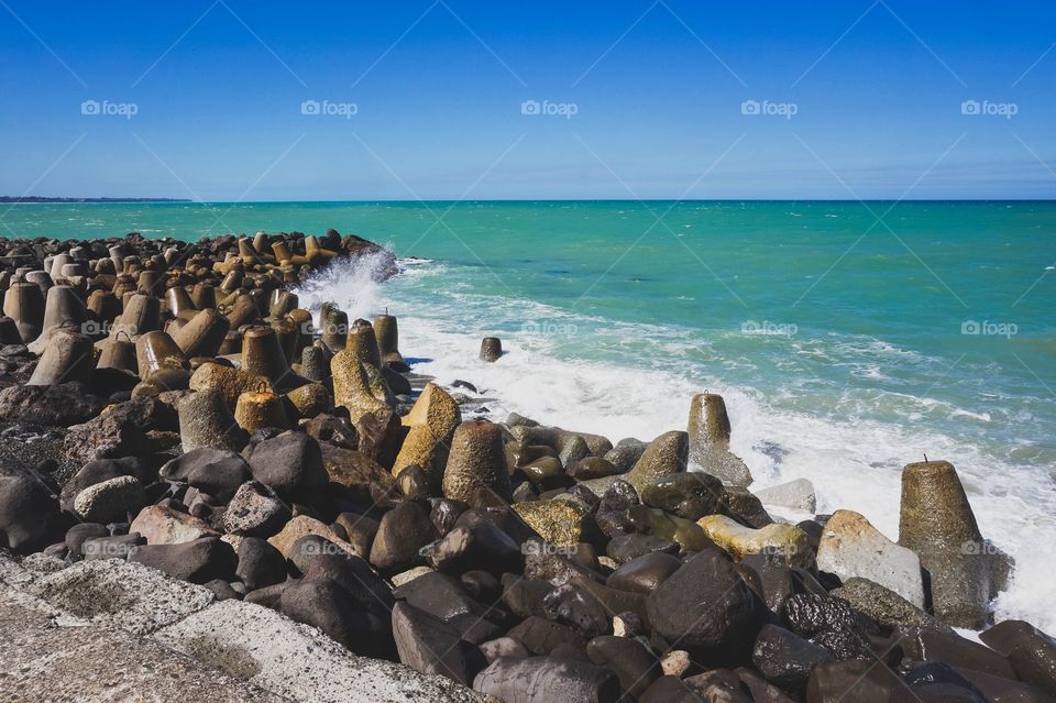 Dolos, boulders and beautiful sea green water at the Oamaru Breakwater, New Zealand 