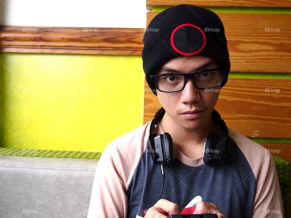 teenage boy wearing bonnet using a smartphone