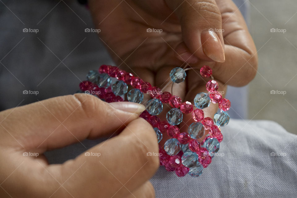 Close-up of woman's hand making bracelet