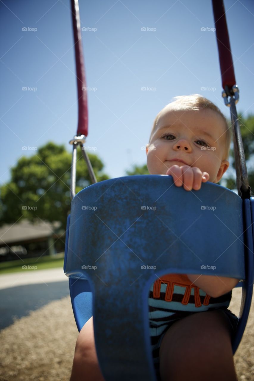 Baby boy in baby swing