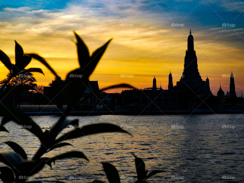 The silhouette of Wat Arun sits across the Chao Phraya River. Taken in Bangkok, Thailand.
