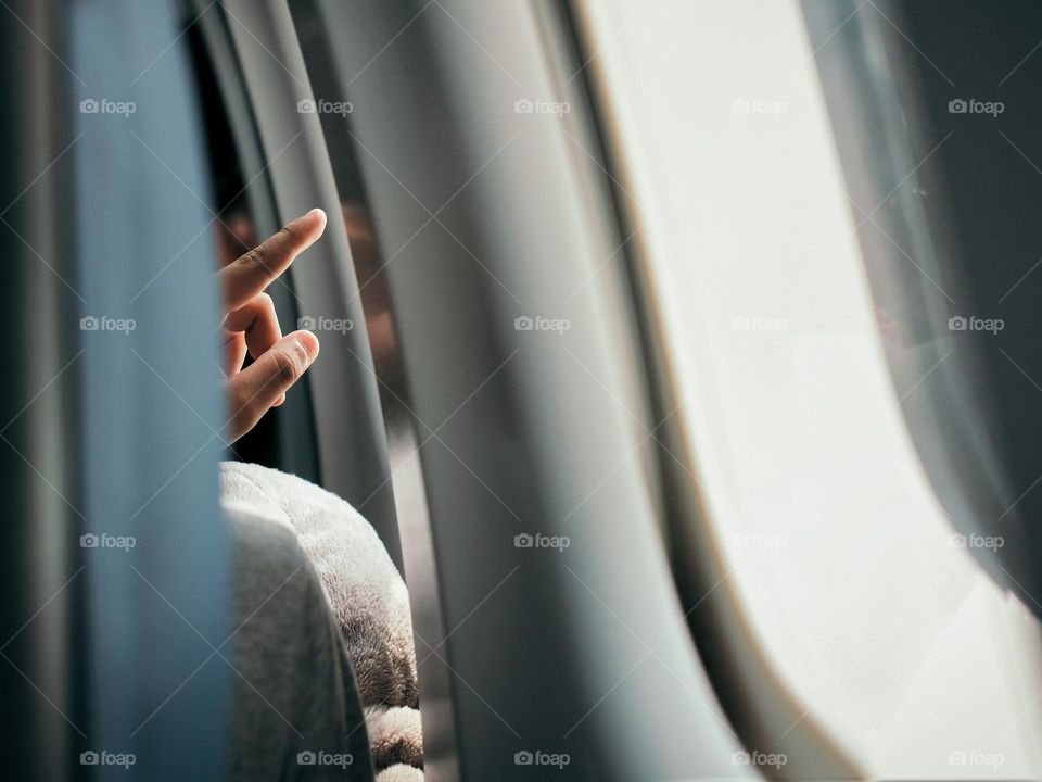 A boy pointing out from an aircraft window