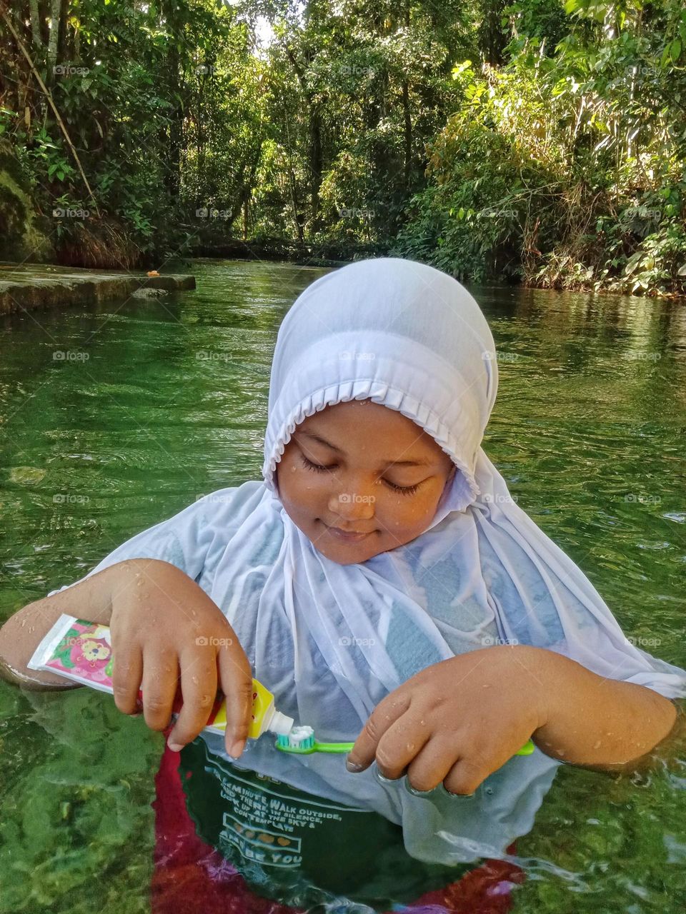 A little girl is preparing the equipment to brush her teeth.