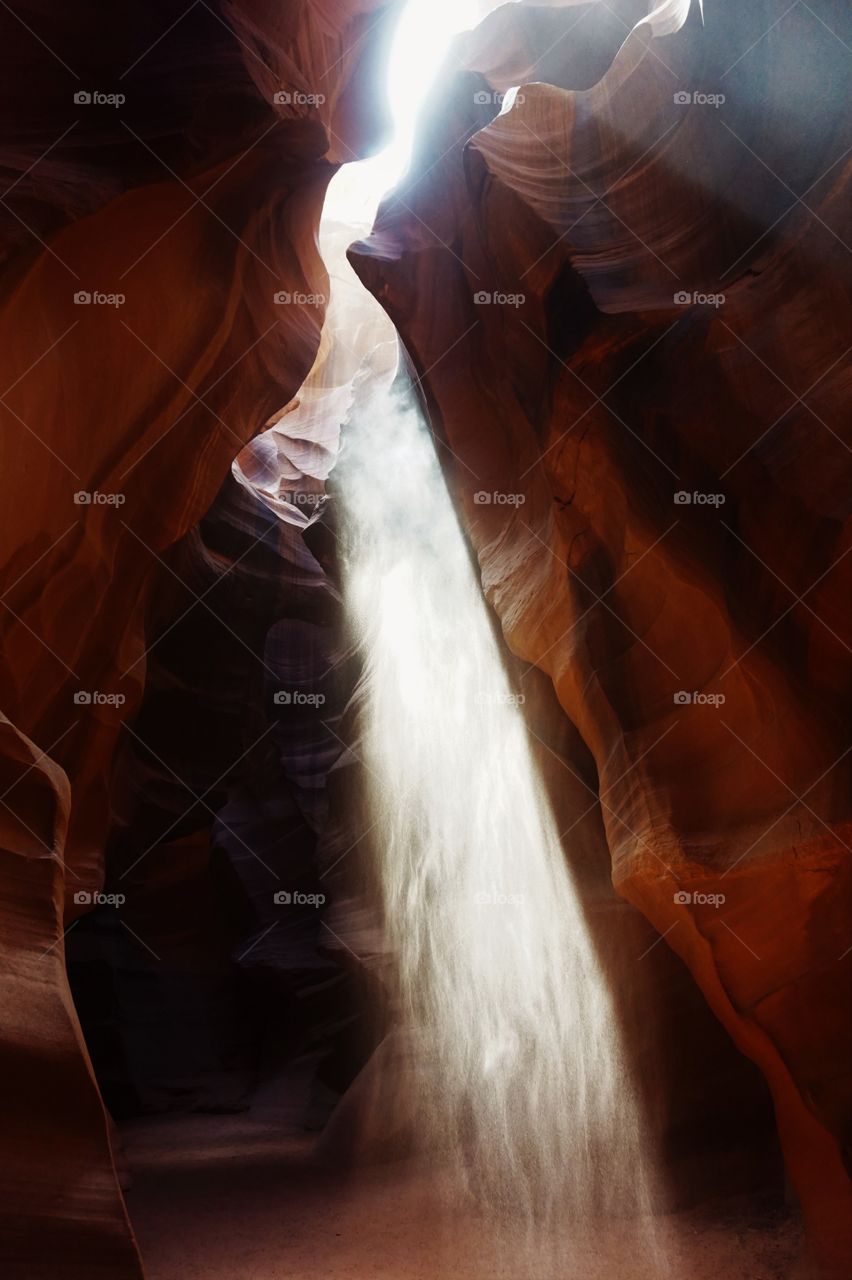 ray of light from the top of a canyon illuminated the dark