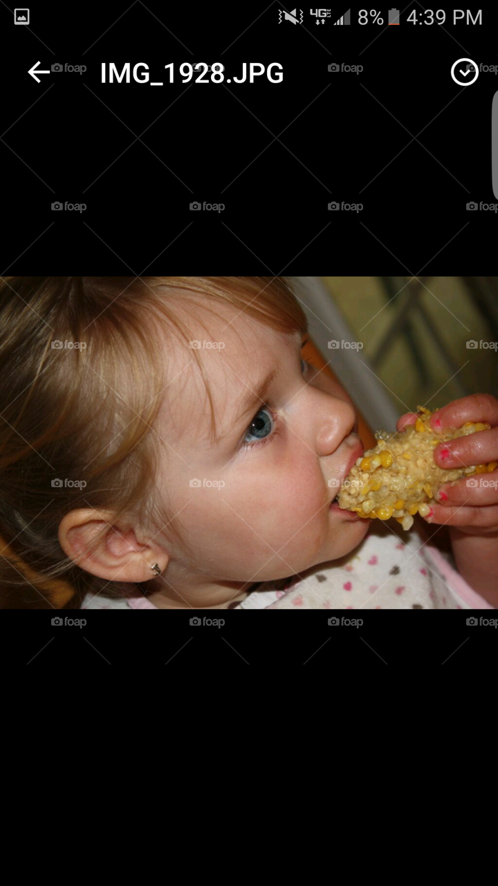 Little girl eating corn on the cob
