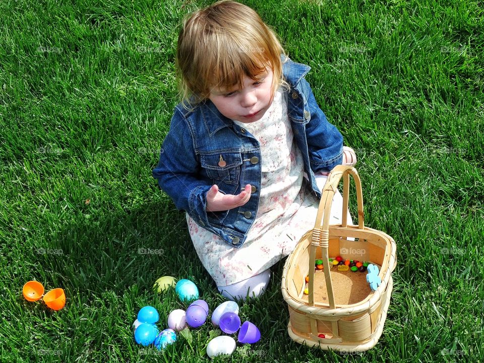 Easter Egg Hunt. Young Girl On The Grass With Basket Of Colorful Easter Eggs
