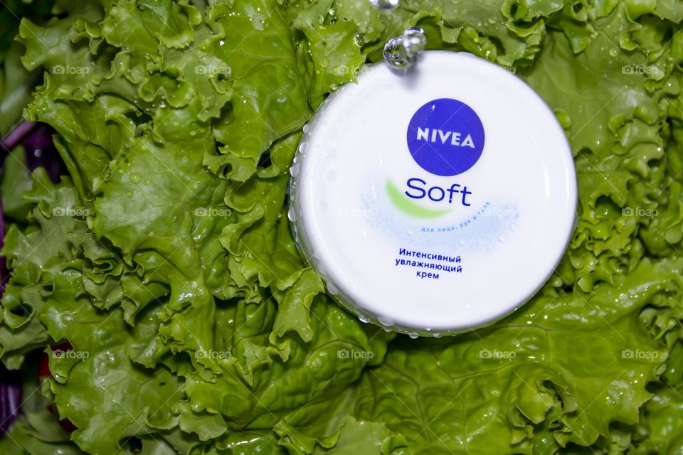 Cosmetic product, Nivea skin care cream on the background of fresh salad with water splashes.