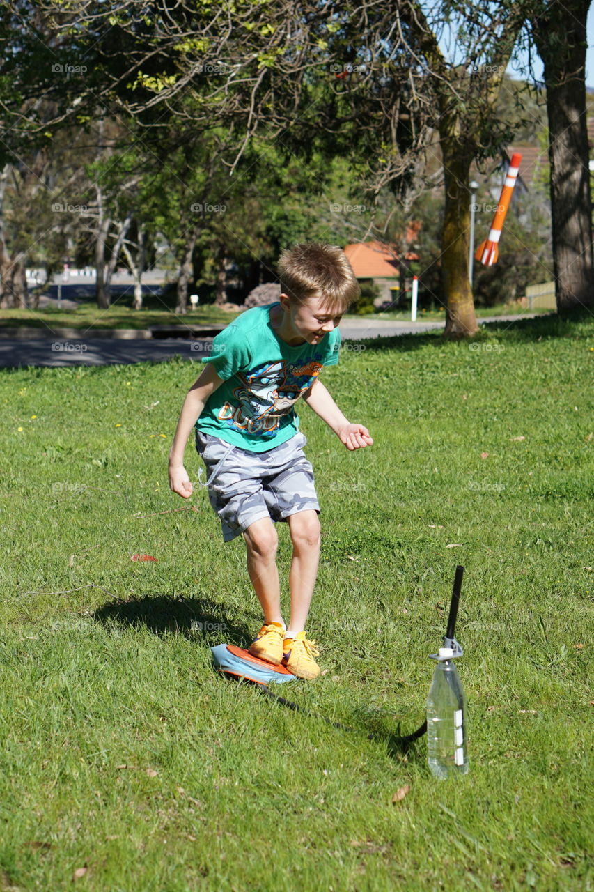 Rocketry. Boy firing an air propelled rocket in the park