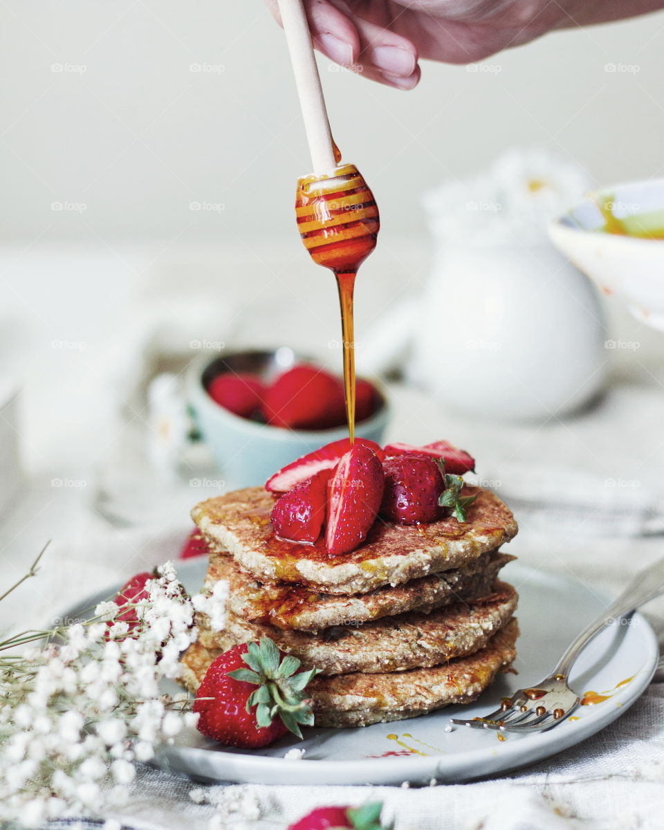 pancakes with strawberries and honey on the top