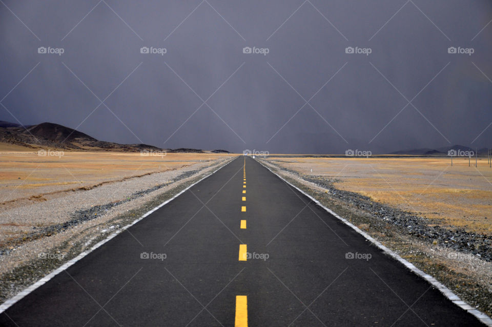 Empty road leading toward mountains