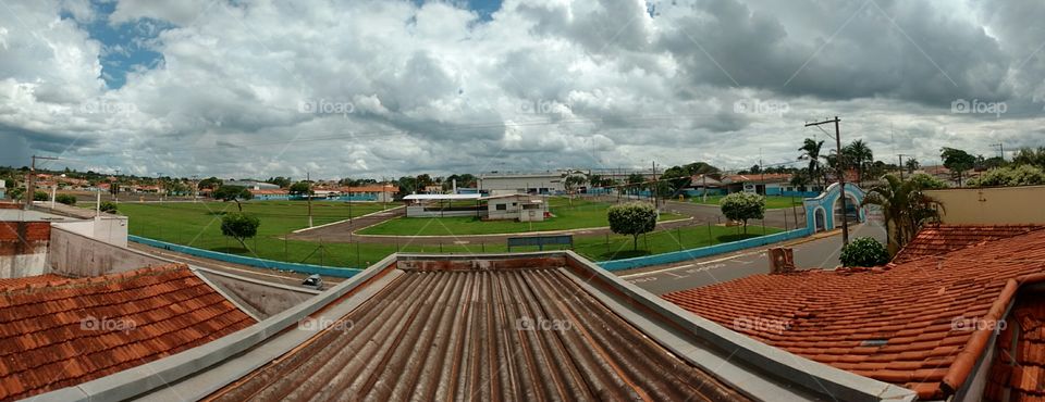 Imagem panorâmica sobre os telhados em cidade pequena do interior.