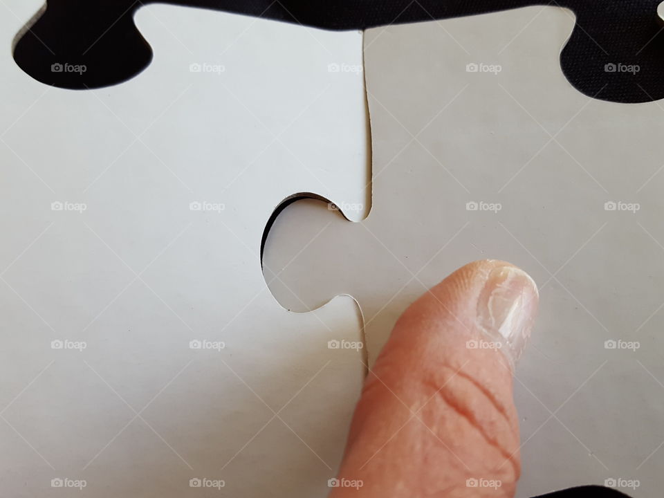 Extreme close-up of human finger with puzzle