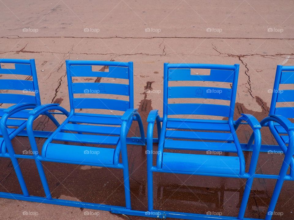 Iconic blue chairs on the Promenade des Anglais overlooking the sea.