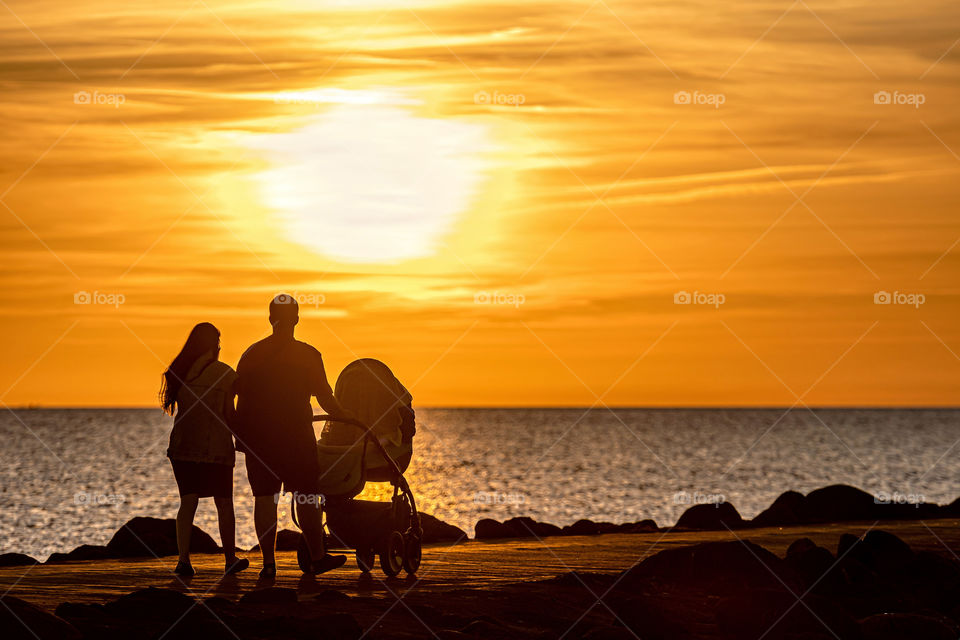 silhouette of family walking on the pier during the golden hour of sunset