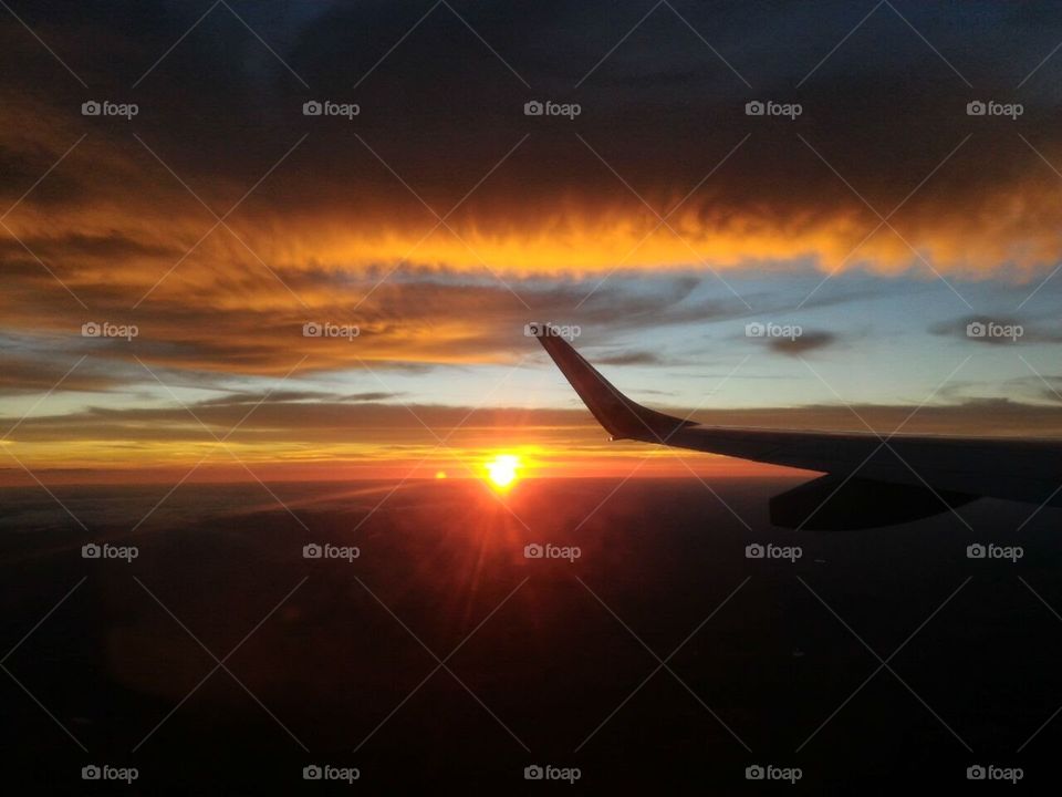 foto do por do sol lindo em uma viagem de avião