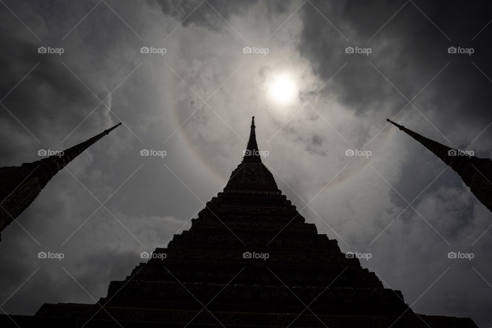 Bangkok/Thailand-August 24 2019:Full halo sun over Beautiful Pagoda at The Temple of  The Reclining Buddha (Wat Pho) in Bangkok