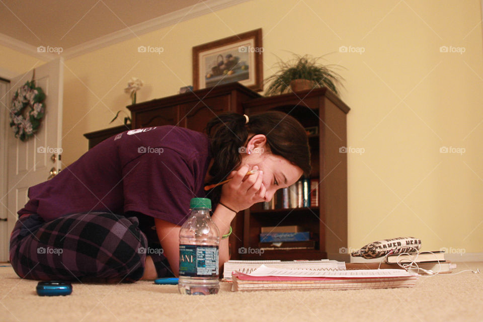 girl studying on floor with a bottle of water