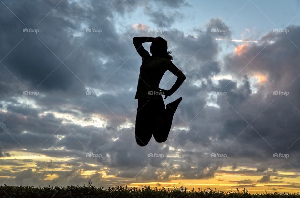 Silhouette of a girl jumping at Sunset 