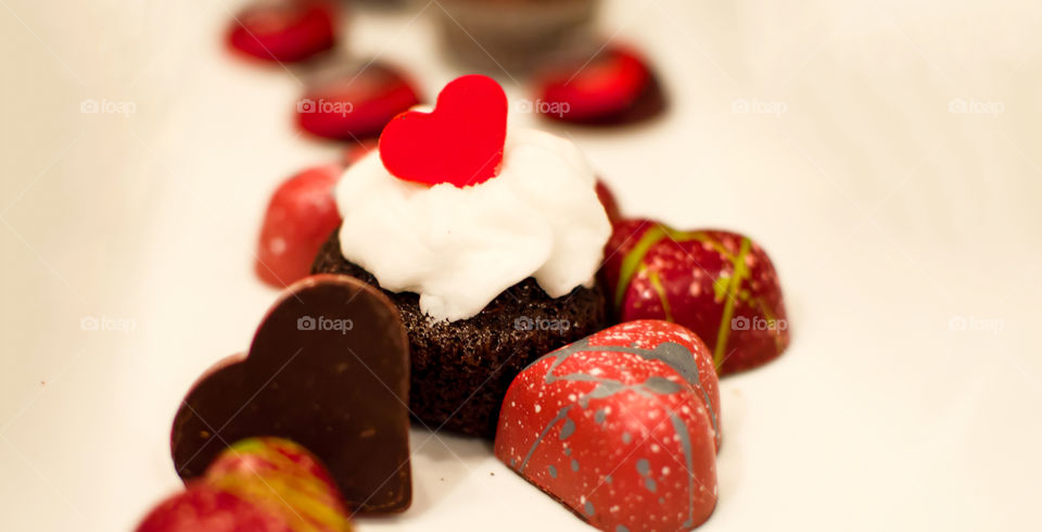 Chocolate cupcake with gourmet dark chocolate hearts on white background romance, love and Valentine's Day theme treats 
