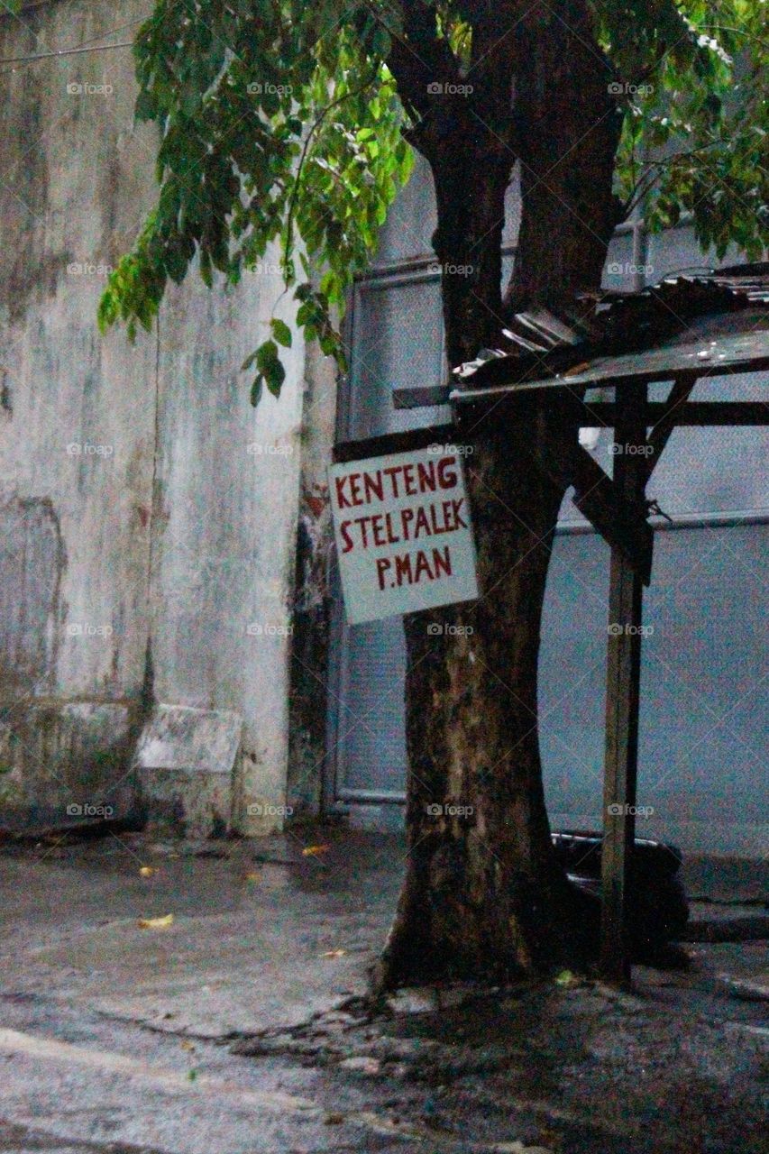 Close-up of a wheel fitting workshop under a tree in the rain