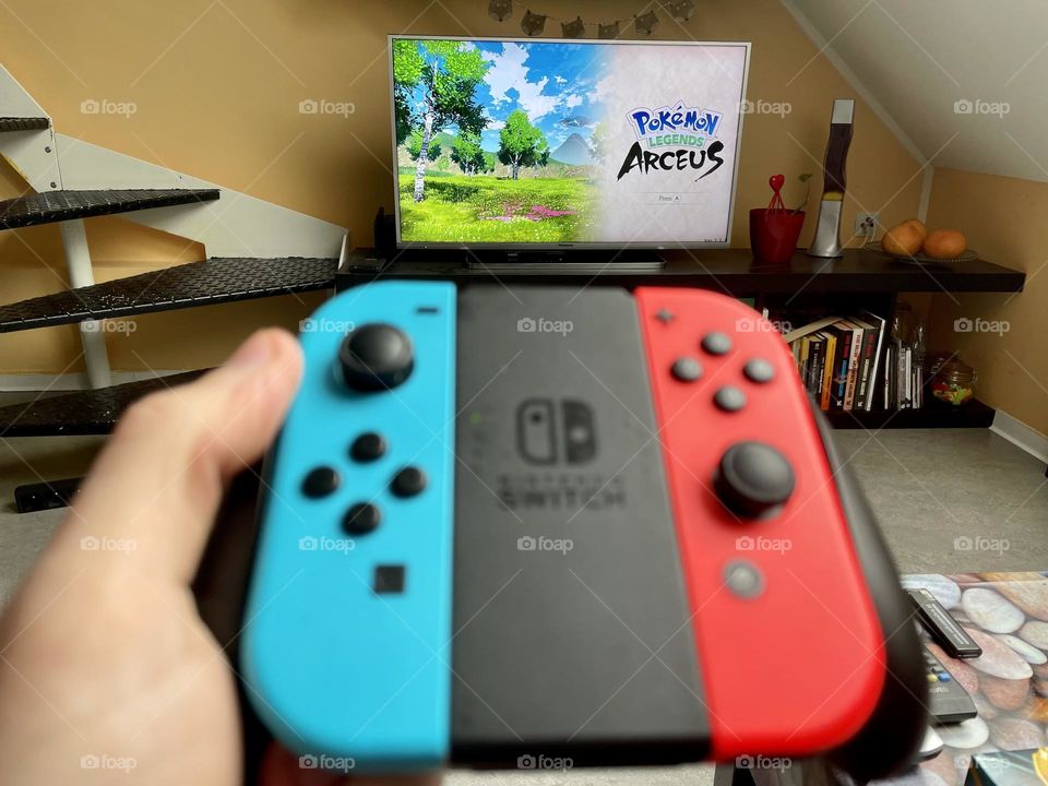 Pokemon Legends Arceus a video game published by the Pokemon Company and Nintendo for the Nintendo Switch on the TV in the living room.