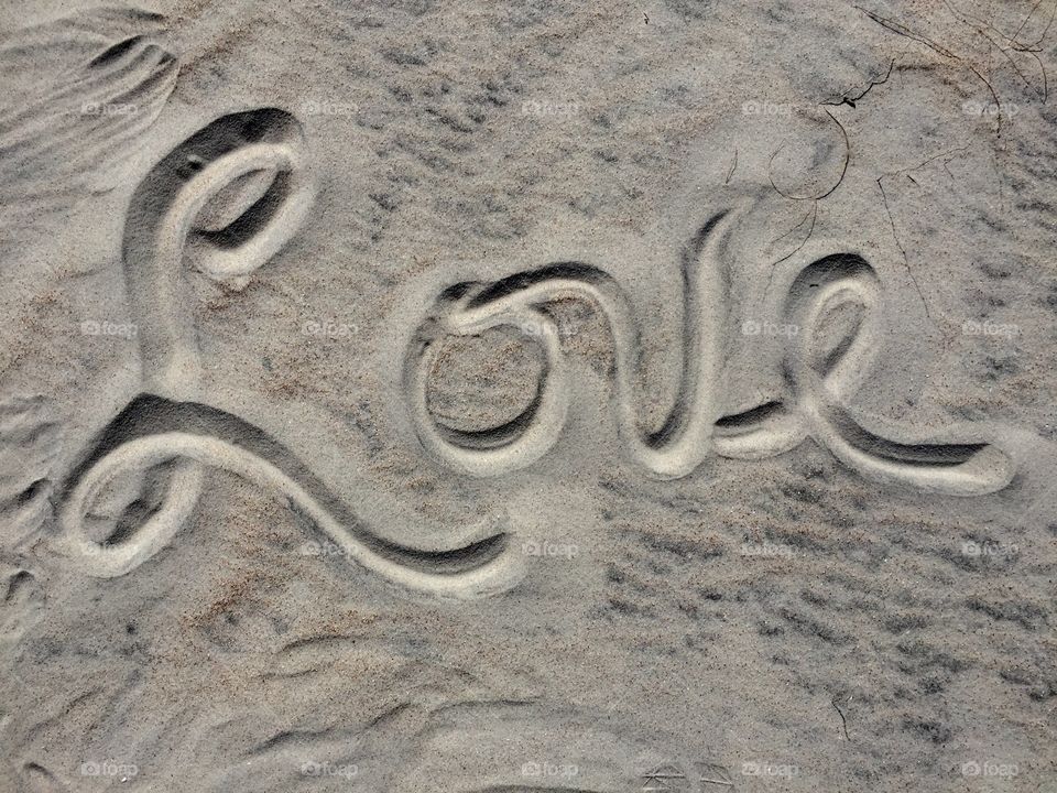 Overhead view of text on sand at beach