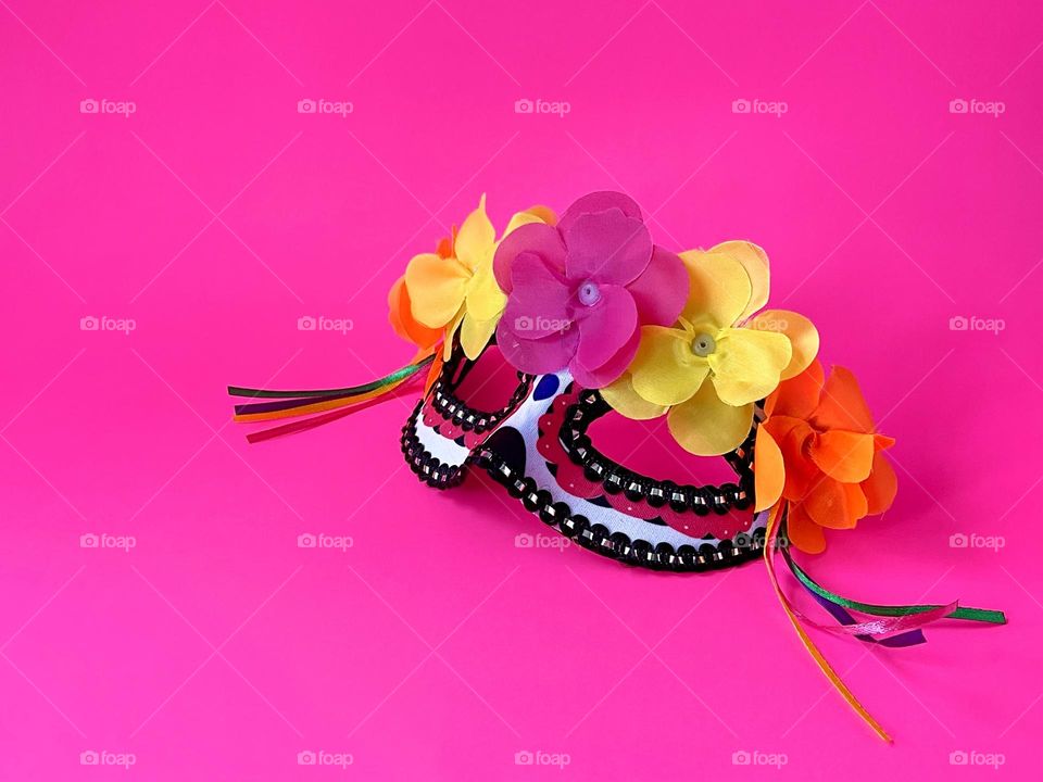 Mexican mask with flowers on the pink background 