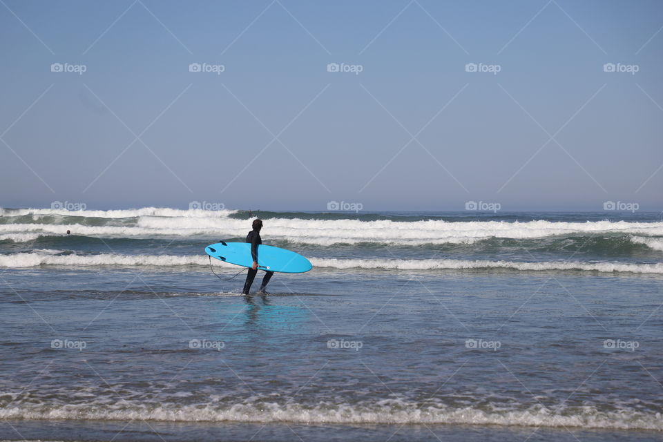 Surfer heading in the ocean