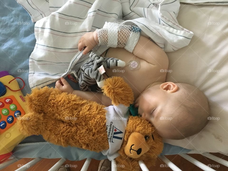 Injured baby lying on bed with electrodes on chest