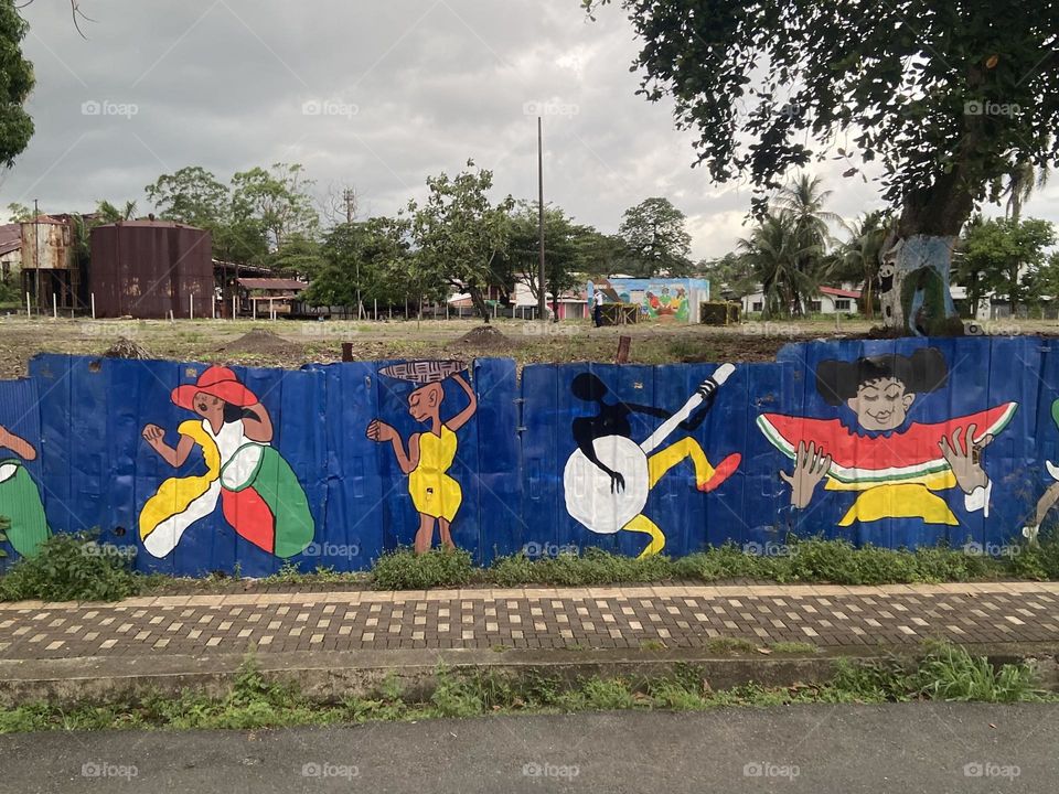 Brightly colored painted fence hiding the deep poverty of Costa Rica.
