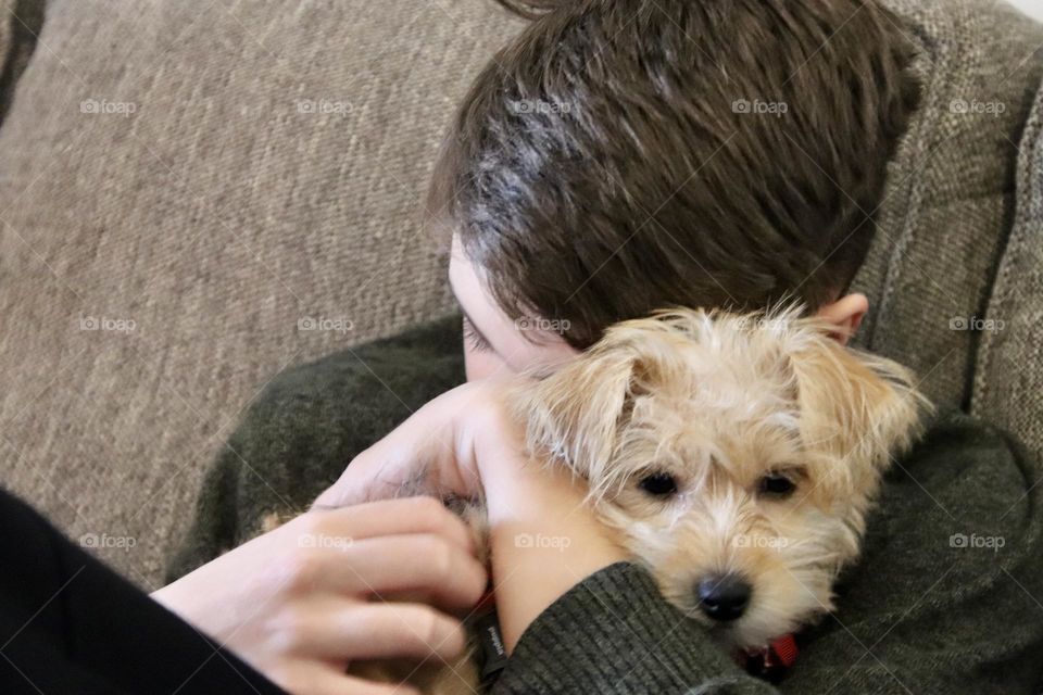 Boy hugging puppy