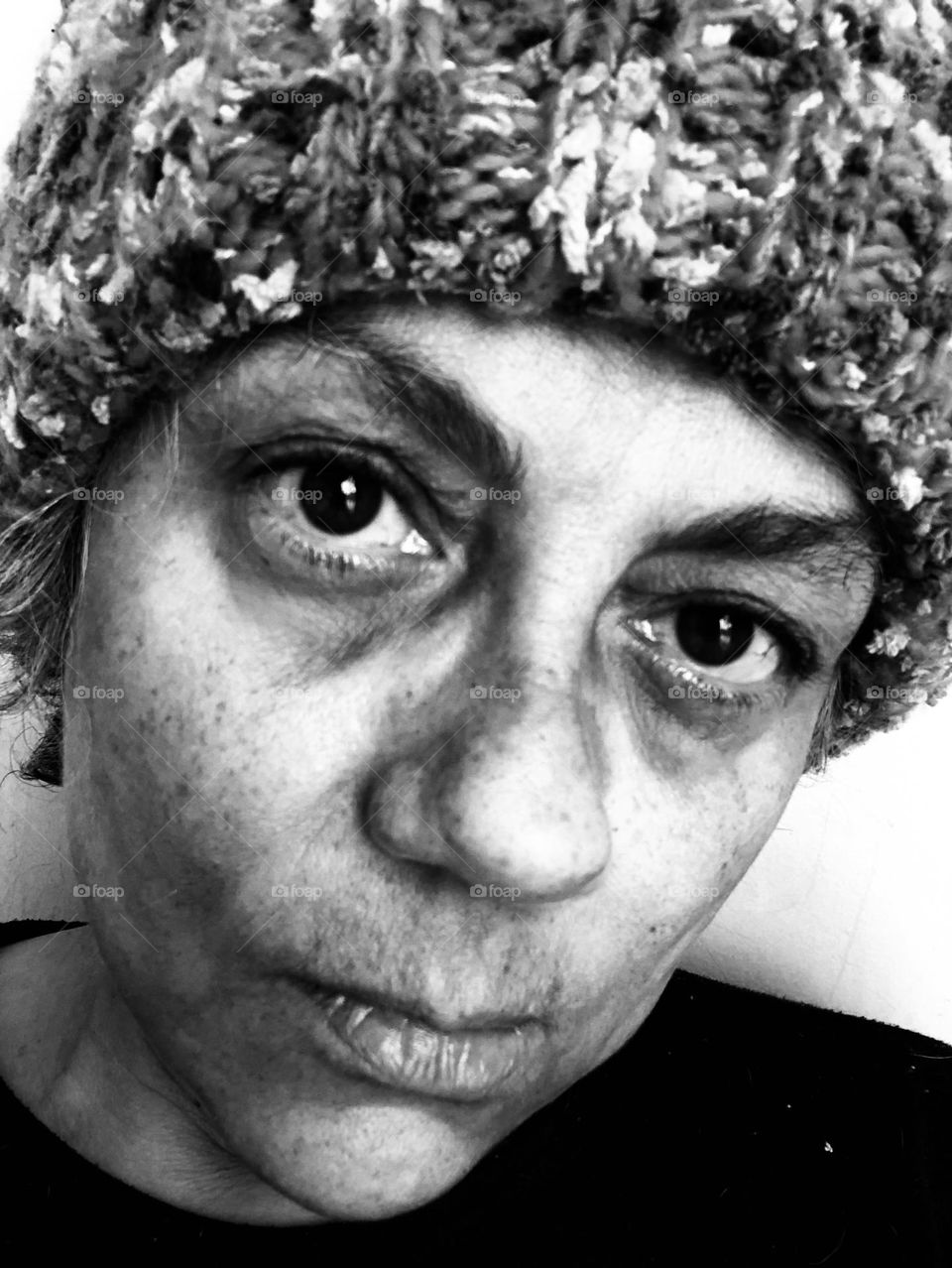 Woman in a wool hat shows her emotions for being stuck indoors during a particular cold winter weekend.