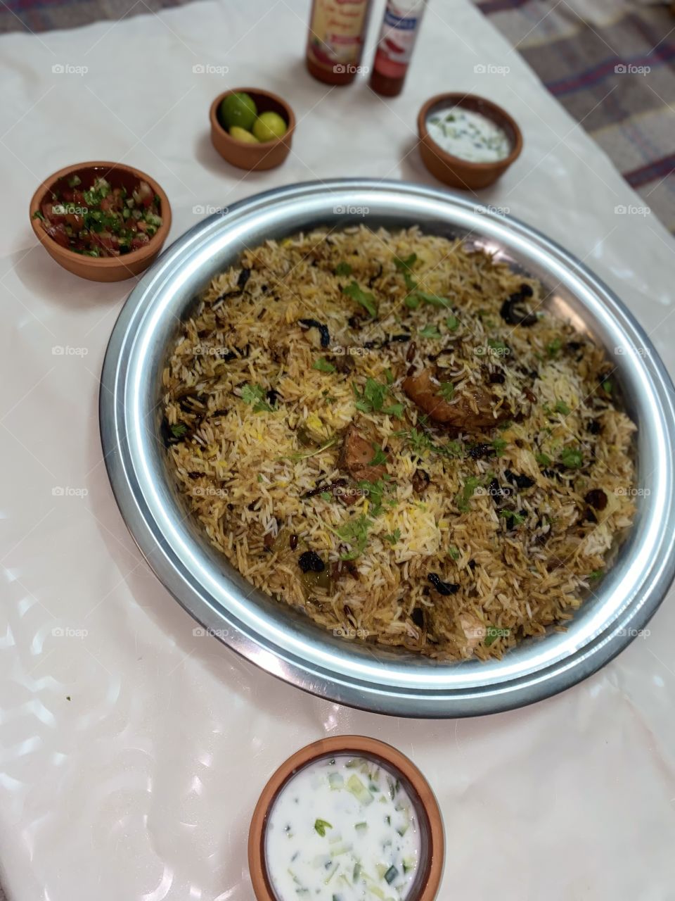 Upside-down kabsa with nuts, tomato and cucumber salad, yogurt and cucumber salad