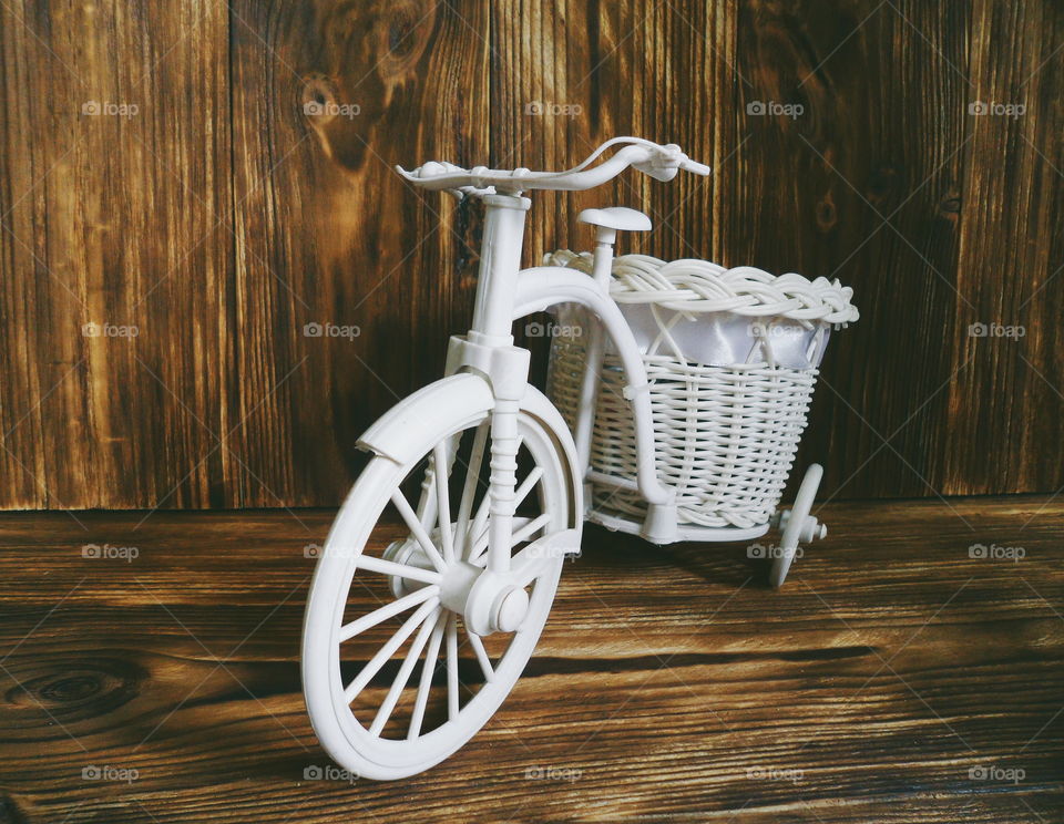 decorative children's bicycle on a dark background of boards