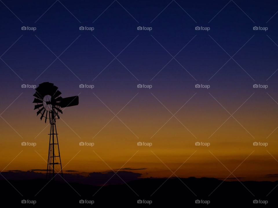 Silhouette of wind turbine during dusk